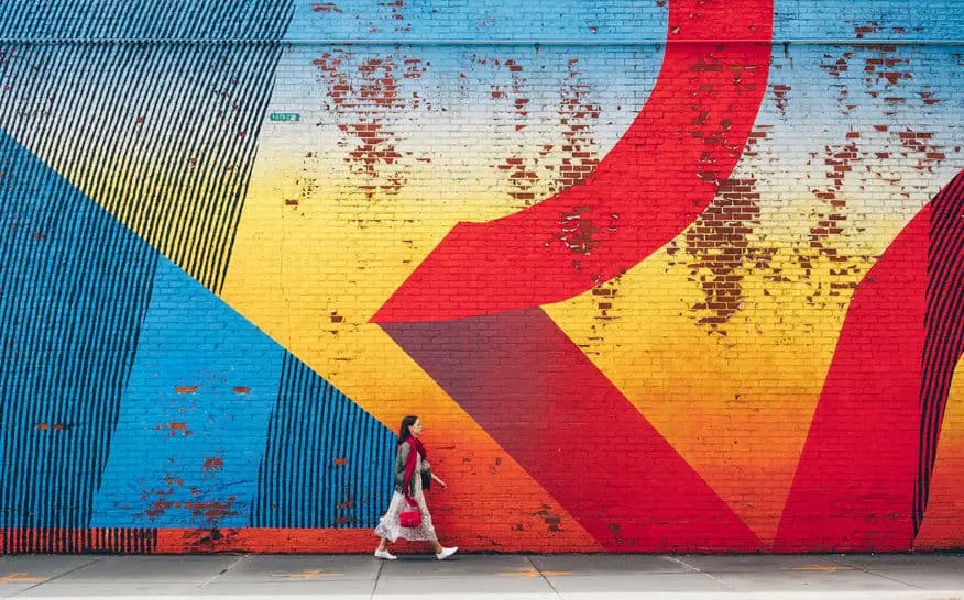 A Girl Walking By Street Graffiti Art in New York City