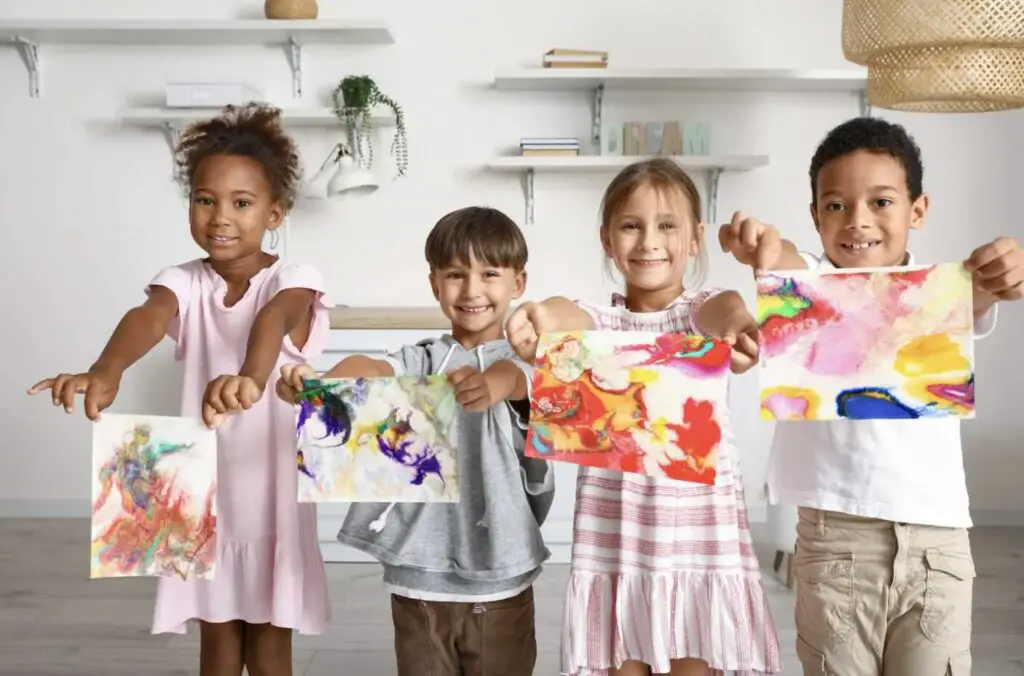 A group of young kids showing their paintings