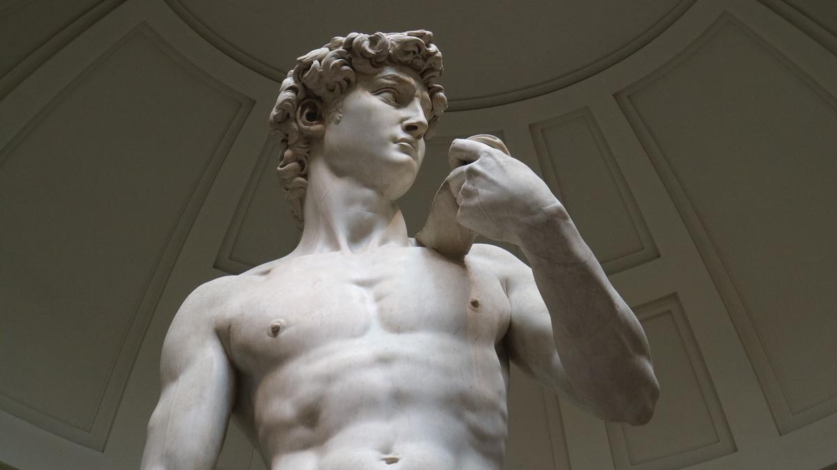 An image of Michelangelo's David, a magnificent marble statue standing tall in the Galleria dell'Accademia in Florence, serving as a symbol of artistic and political autonomy.